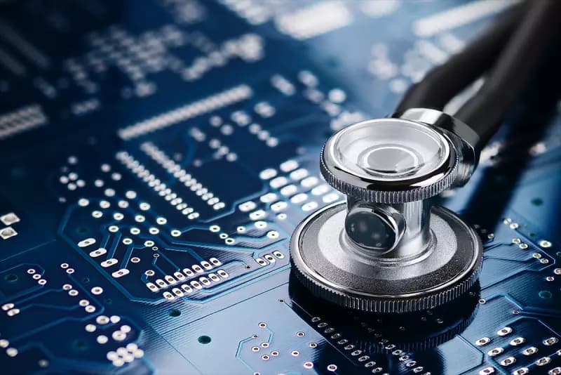 Medical stethoscope resting on a blue circuit board, symbolising healthcare technology and digital medicine.